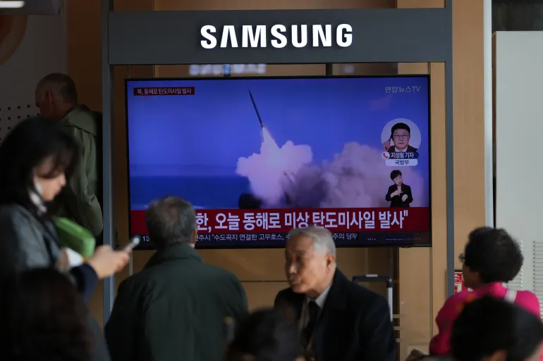 A TV screen shows footage of missiles.