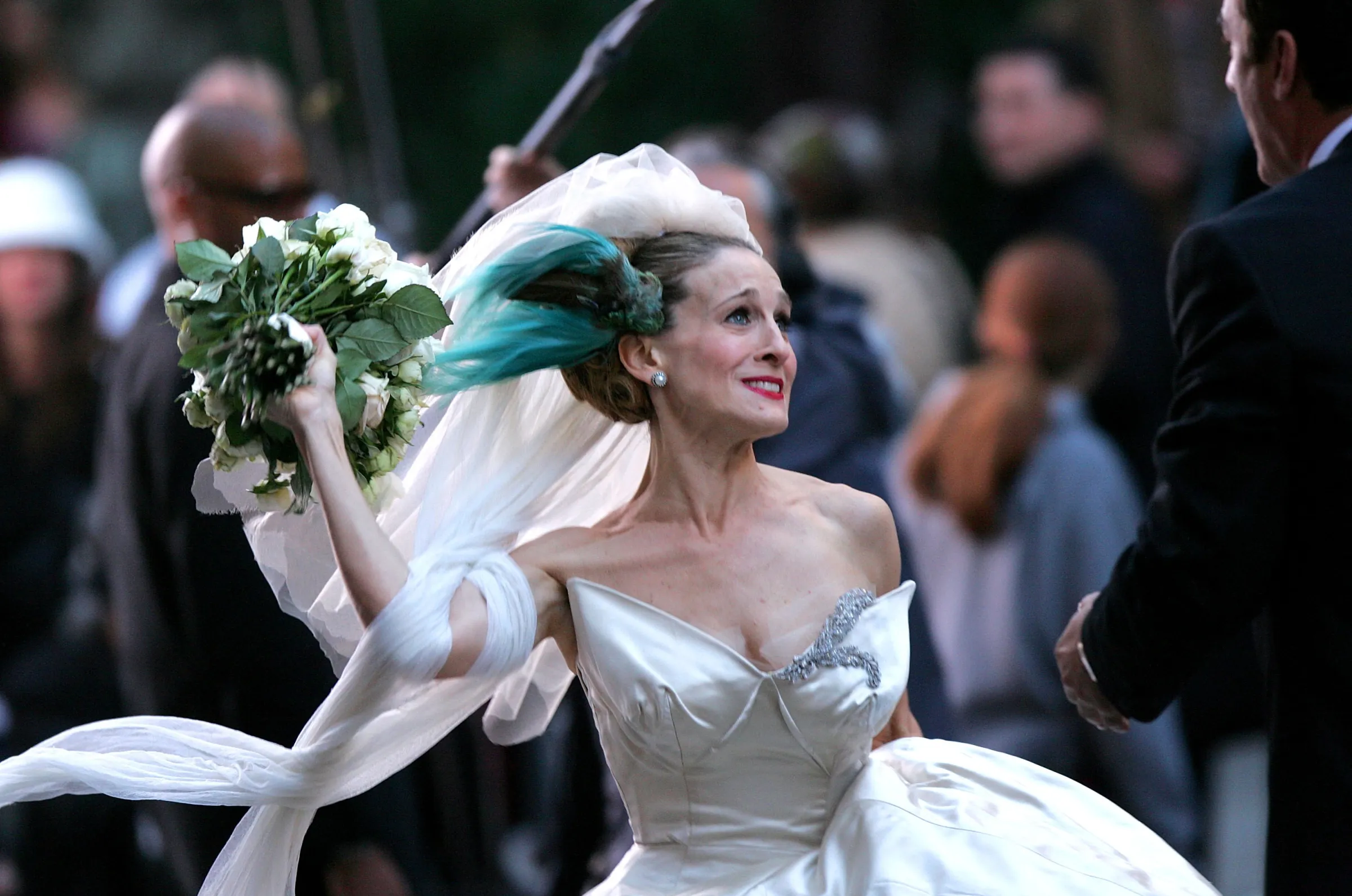 Sarah Jessica Parker as Carrie Bradshaw in a wedding dress, about to throw a bouquet.