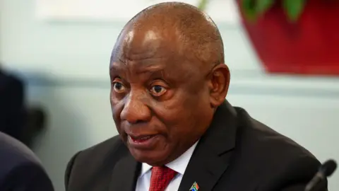 Reuters South Africa's President Cyril Ramaphosa wears a dark blazer and red tie. 