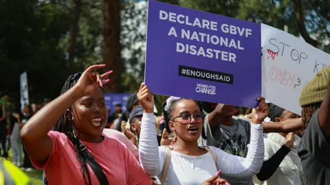 AFP via Getty Images Protesters sing and chant during a demonstration calling for gender-based violence and femicide to be declared a national disaster at the Union Buildings in Pretoria on April 11, 2025