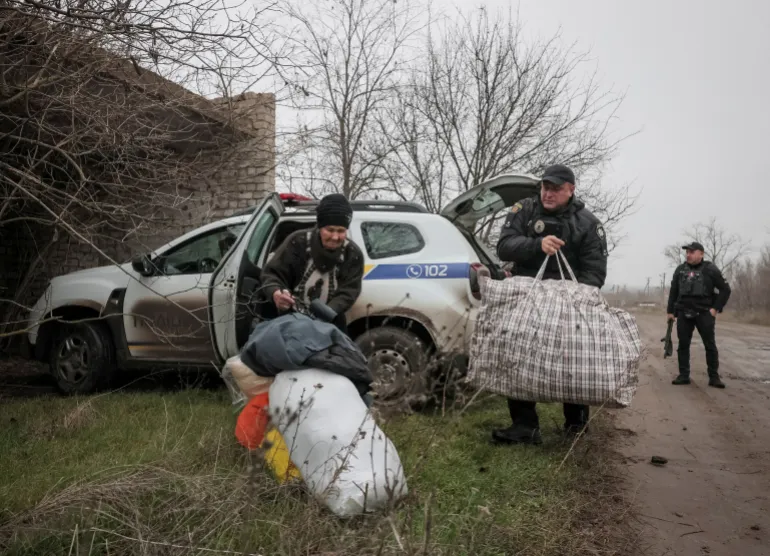 Police officers assist a resident during an evacuation from the frontline town of Huliaipole, amid Russia's attack on Ukraine, in Zaporizhzhia region, Ukraine November 11, 2025. REUTERS/Sergiy Chalyi TPX IMAGES OF THE DAY