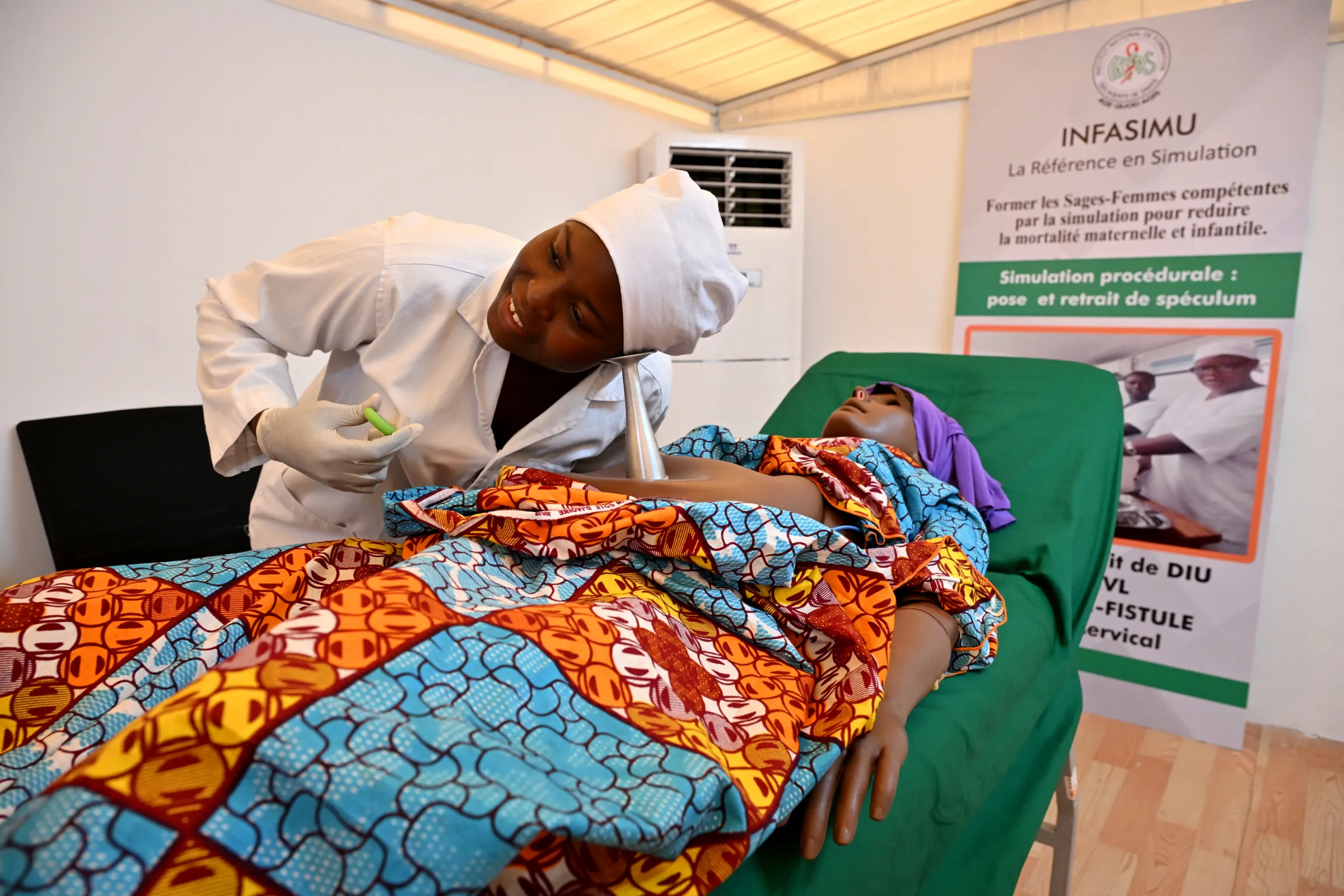 A woman enrolled in a midwife training schools engages in a training session on maternal care.