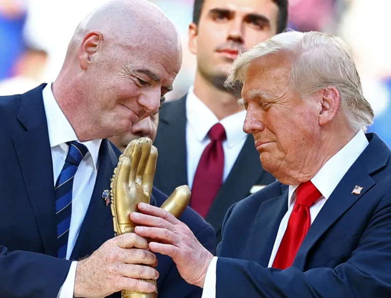 U.S. President Donald Trump looks at the golden glove trophy next to FIFA president Gianni Infantino after Chelsea won against Paris St Germain in the FIFA Club World Cup final