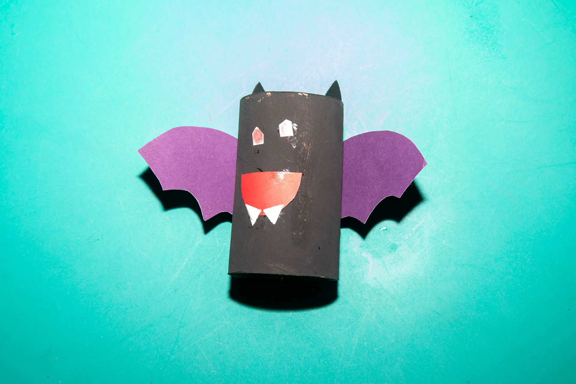 a kid-crafted paper bat painted black and purple