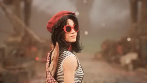 Sandfall Interactive A screenshot from Clair Obscur shows a character with shoulder-length dark hair looking back over her shoulder at the viewer. She wears a red beret, large, red-rimmed sunglasses and a white tank top with thin grey stripes. A knapsack with a baguette poking out of it is slung over her shoulder.