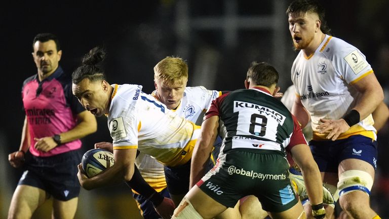 Leinster's James Lowe is checked as he charges through