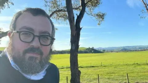 Supplied A middle aged man with glasses looks at the camera, behind him is a grassy field.