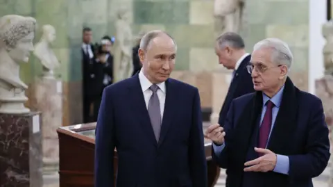 AFP via Getty Images Two white middle-aged man in an art museum surrounded by ancient busts