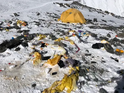 David Liano Camp IV on Everest. A yellow tent surrounded by snow and rubbish. 