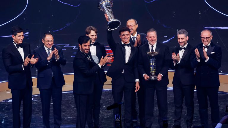 Lando Norris lifts the championship trophy