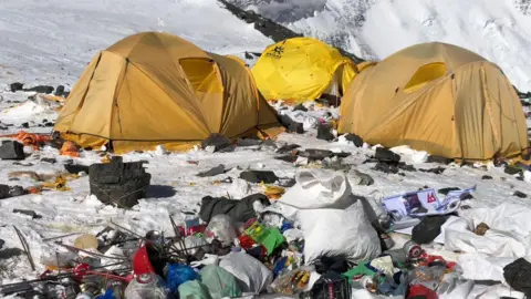 David Liano Camp IV on Everest. A cluster of yellow tents surrounded by snow and rubbish. 