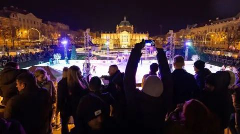 AFP via Getty Images Revellers at Zagreb Advent, the city's Christmas market
