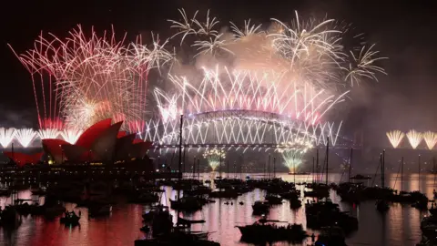 AFP via Getty Images Fireworks lit up the midnight sky over Sydney Harbour Bridge and Sydney Opera House during New Year's Day celebrations in Australia