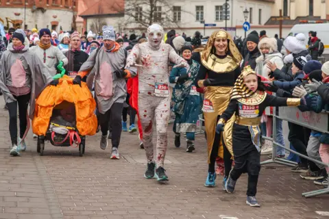 Getty Images People dressed in funny costumes attend the traditional Krakow New Year's Run in the Old Town on the New Year's Eve in Krakow, Poland