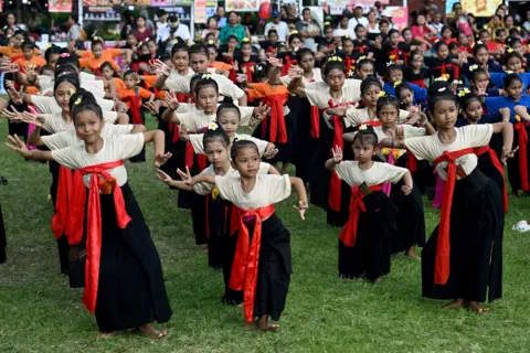 AFP via Getty Images Children perform a traditional Balinese dance to release the sun of 2025, and to welcome the sun of 2026, during a New Year's Eve celebration in Denpasar, on Indonesia's resort island of Bali on December 31, 2025.