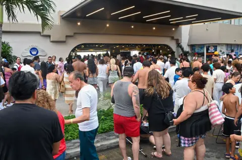 Getty A large crowd of people wait outside a hotel after an earthquake caused them to leave their rooms