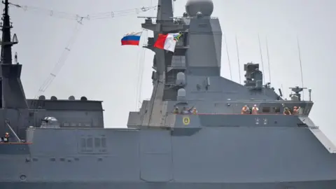 AFP/Getty Images A close-up of a Russian warship - some officers can been seen looking at the view as they come into the harbour.