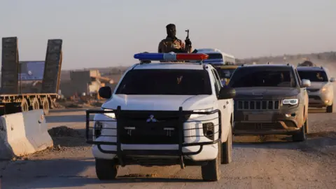 Reuters Syrian government forces advance along a road in Hassakeh province, north-eastern Syria (20 January 2026)