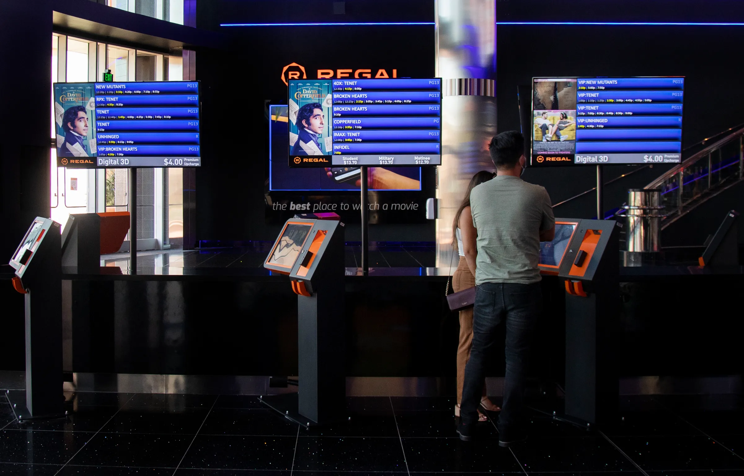 Patrons looking at upcoming showtimes at a Regal cinema