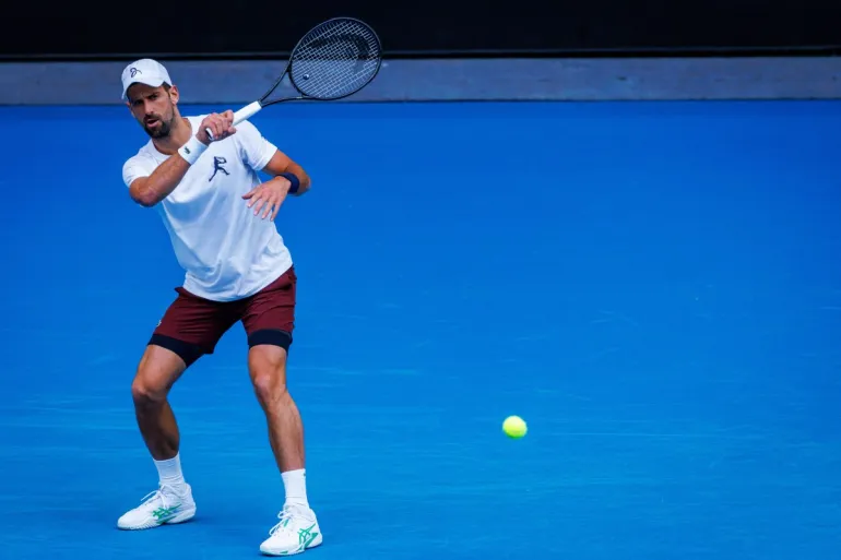 Serbia’s Novak Djokovic hits a forehand during a training session against Czech Republic Jiri Lehecka in preparation for the Australian Open in Melbourne on January 13, 2026. (Photo by Patrick HAMILTON / AFP) / - IMAGE RESTRICTED TO EDITORIAL USE - STRICTLY NO COMMERCIAL USE -