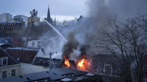 JEROEN JUMELET/EPA/Shutterstock Firefighters work at the scene of a large fire at a house on Visscherssteeg, Utrecht