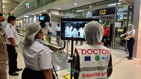 EPA Thai health officials wearing protective masks monitoring passengers from international flights arriving at Suvarnabhumi Airport