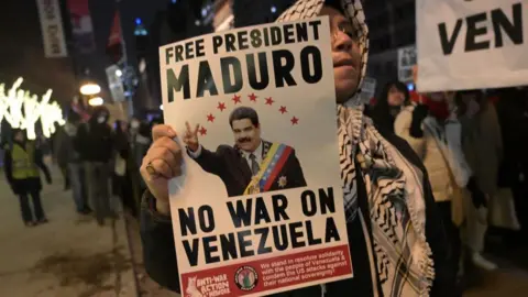 Getty Images Woman holds poster at protest in Chicago which says "FREE PRESIDENT MADURO - NO WAR ON VENEZUELA"