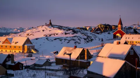 EPA Sun setting on a snow-covered part of Nuuk in Greenland