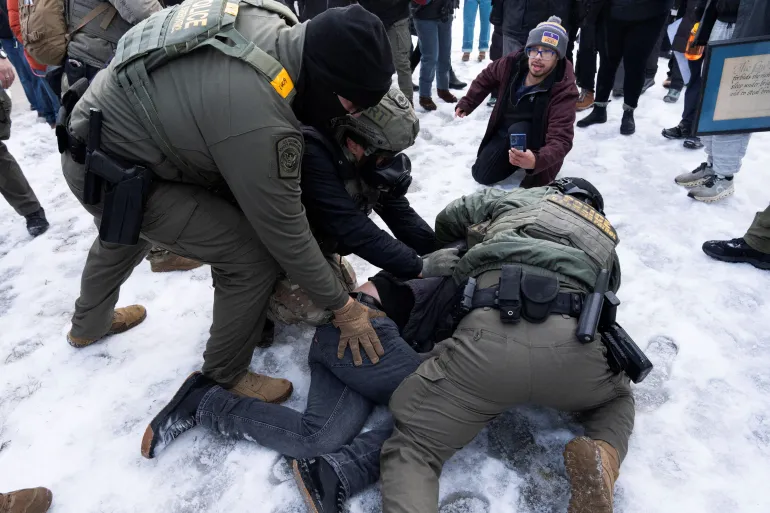 Federal agents tackle a protester to the ground before detaining him outside of the Whipple Federal Building as immigration enforcement action continues, following the fatal shooting of Renee Nicole Good by a U.S. Immigration and Customs Enforcement (ICE) agent, in Minneapolis, Minnesota, U.S., January 8, 2026. REUTERS/Tim Evans