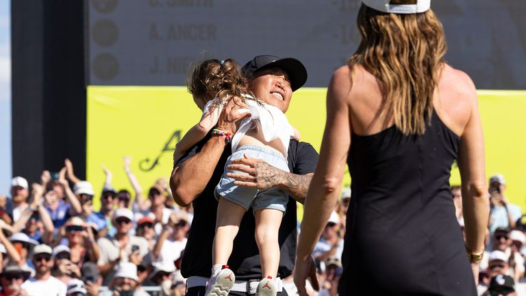 Kim's embraces his daughter Bella (Photo by Jon Ferrey/LIV Golf via AP)
