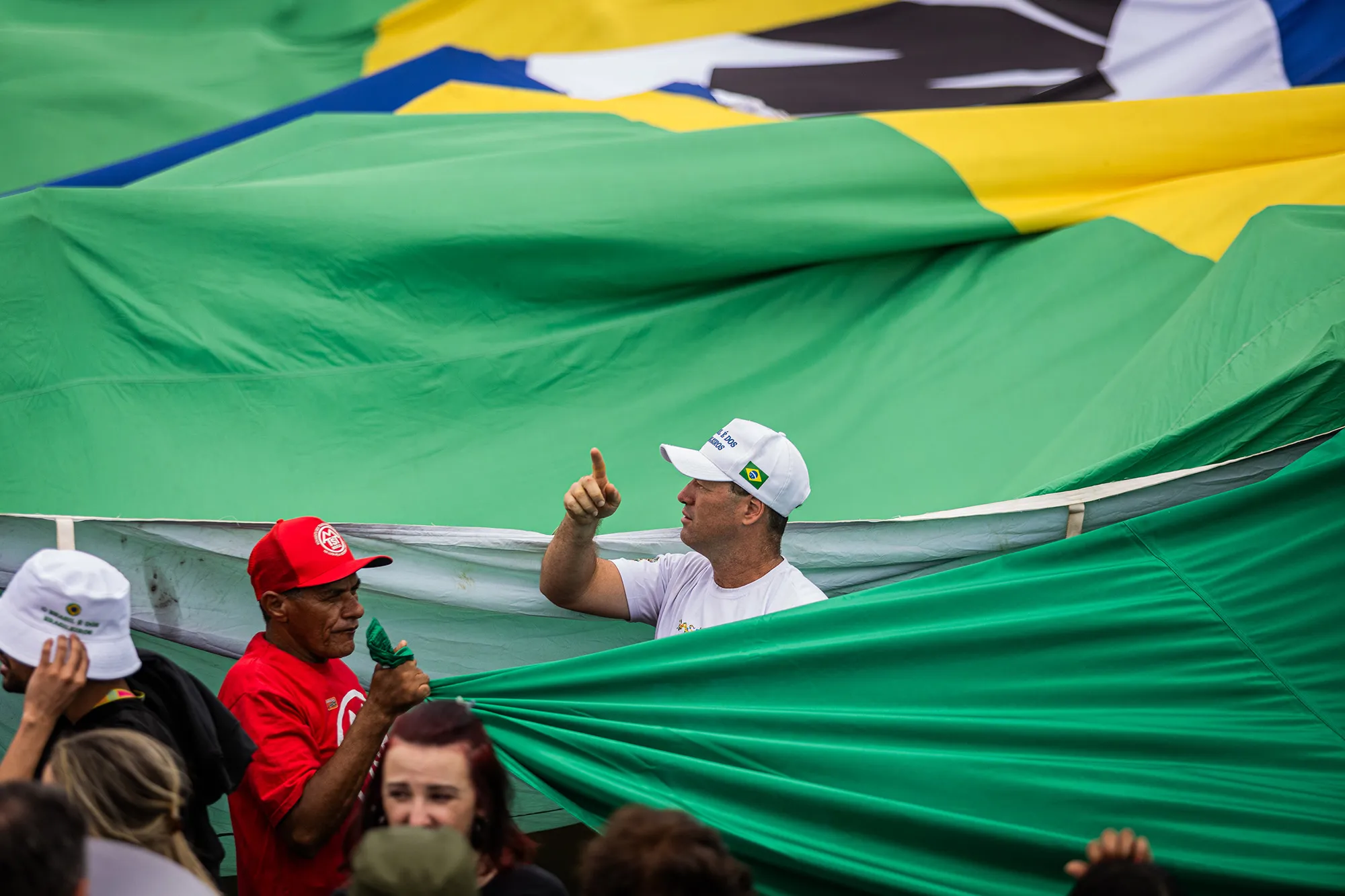 People holding the green part of the Brazilian flag