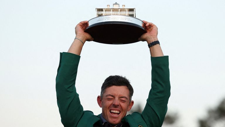 Rory McIlroy celebrates with his green jacket and the trophy after winning The Masters. Pic: Reuters