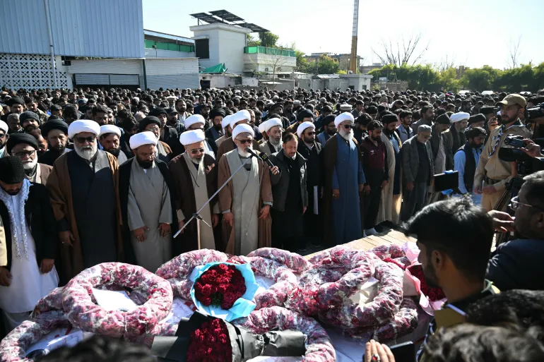 Mourners offer funeral prayers as they stand around the coffin of a Shiite Muslim, a day after a suicide bombing at a mosque in Islamabad on February 7, 2026.