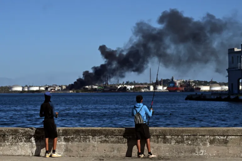 column of smoke rising from the Nico Lopez refinery in Havana Bay, though it was not known if the blaze was near the plant’s oil storage tanks. (Photo by YAMIL LAGE / AFP)