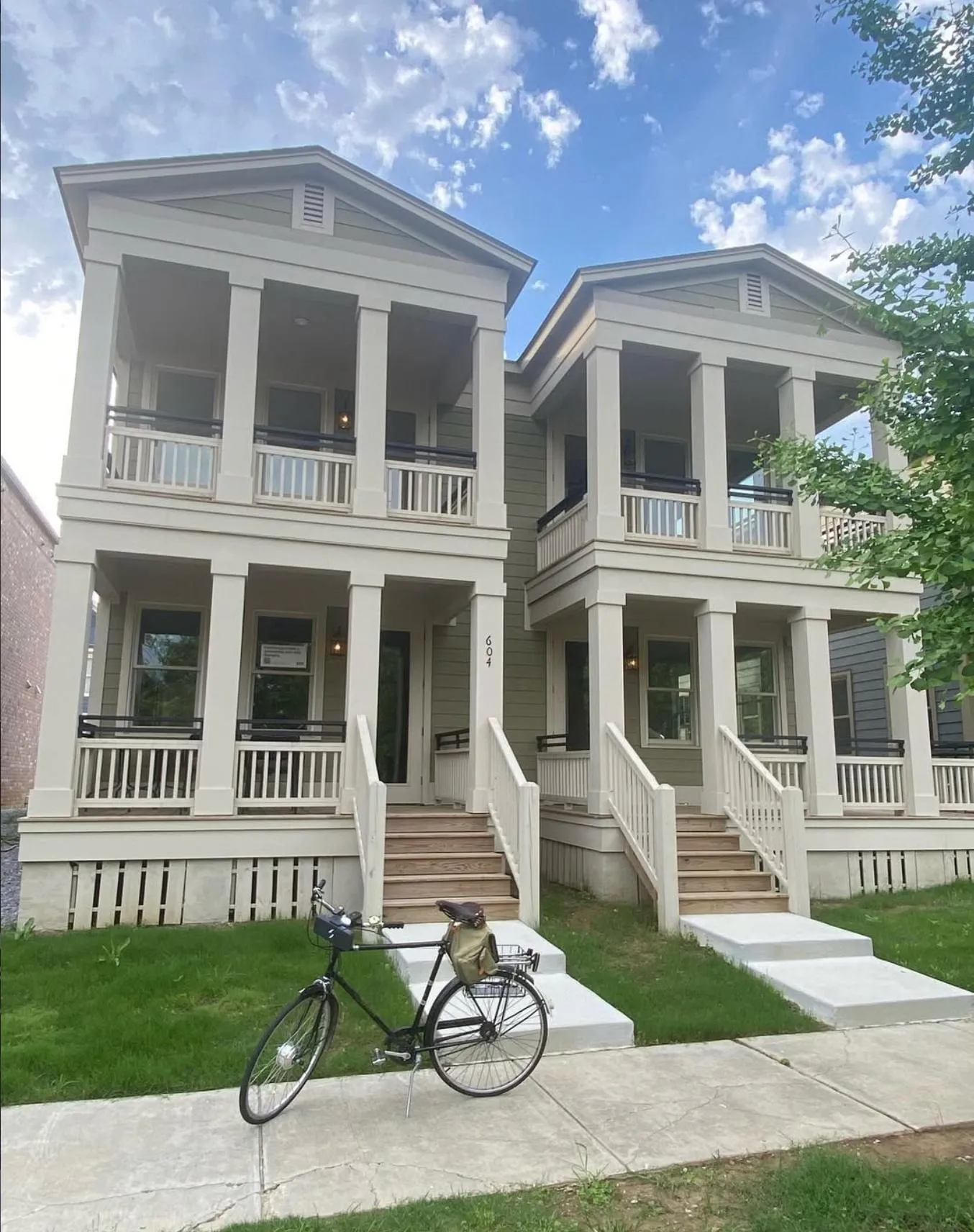 A newly built, two-story fourplex with matching front porches and second-floor balconies.