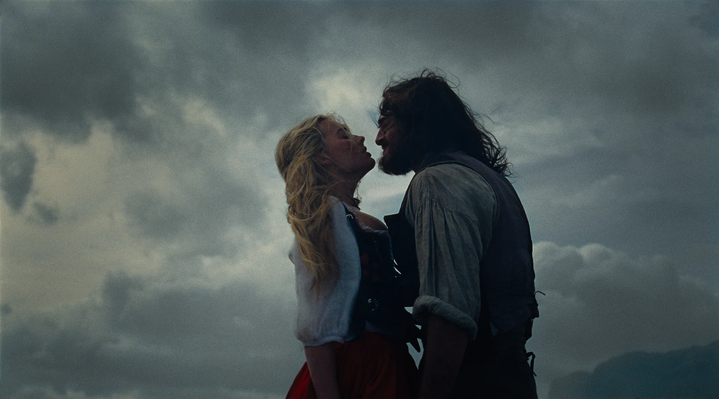 Robbie and Elordi as Catherine and Heathcliff, mid-clinch on the moors.