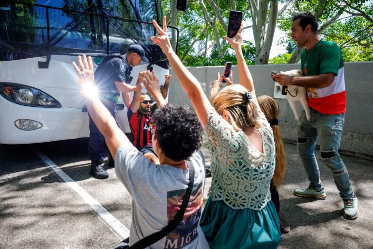 Members of the Iranian community in Australia block the path of a departing bus transporting members of the Iranian Women’s Asia Cup football team to the airport, outside the Royal Pines Resort on the Gold Coast on March 10, 2026. Five players from Iran's visiting women's football team claimed asylum in Australia on March 10, seeking protection after they were branded "traitors" at home for refusing to sing the national anthem. (Photo by Patrick HAMILTON / AFP)