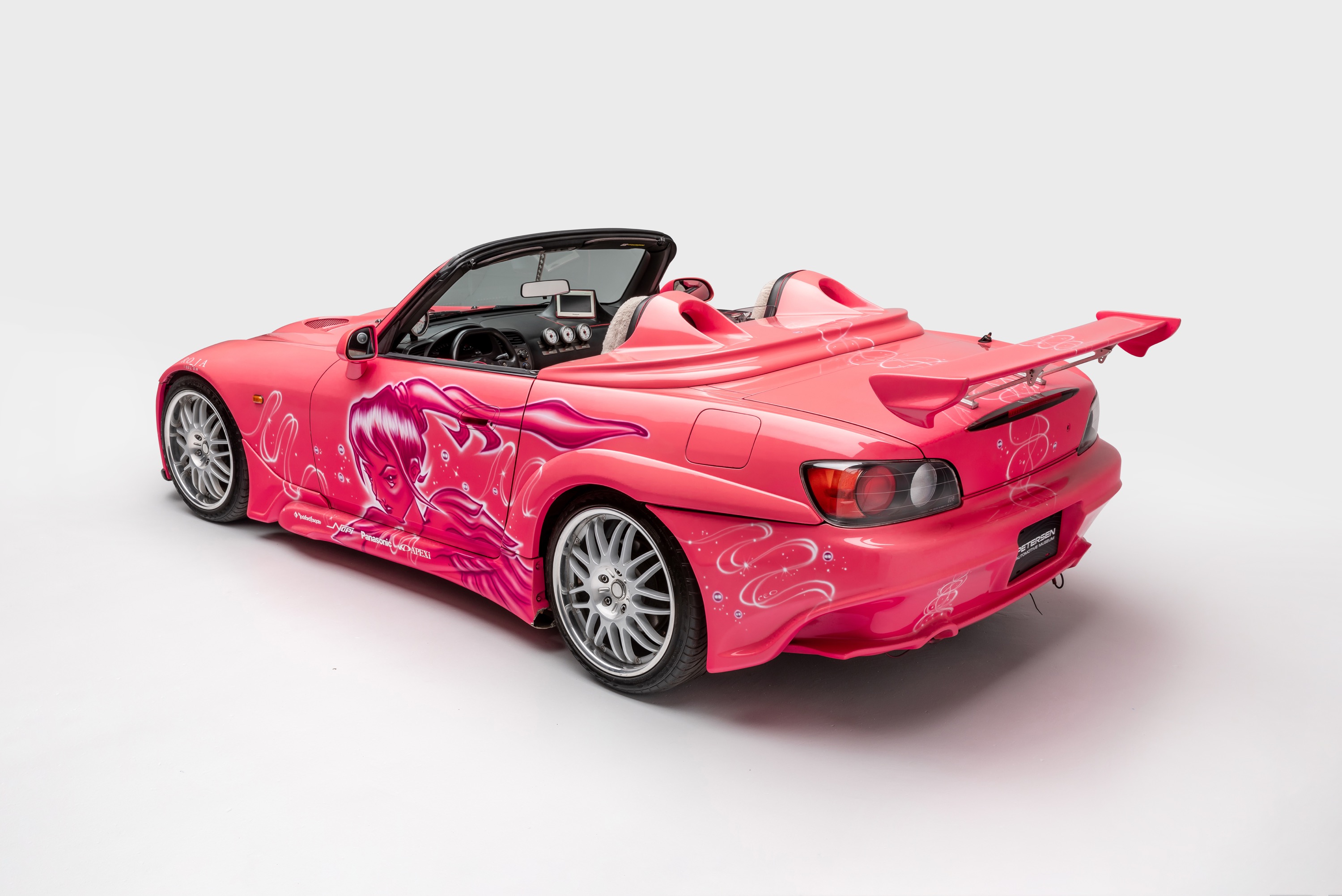 A pink modified Honda S2000.