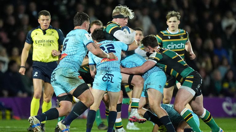 Henry Pollock shields the ball amid a flurry of Castres players 