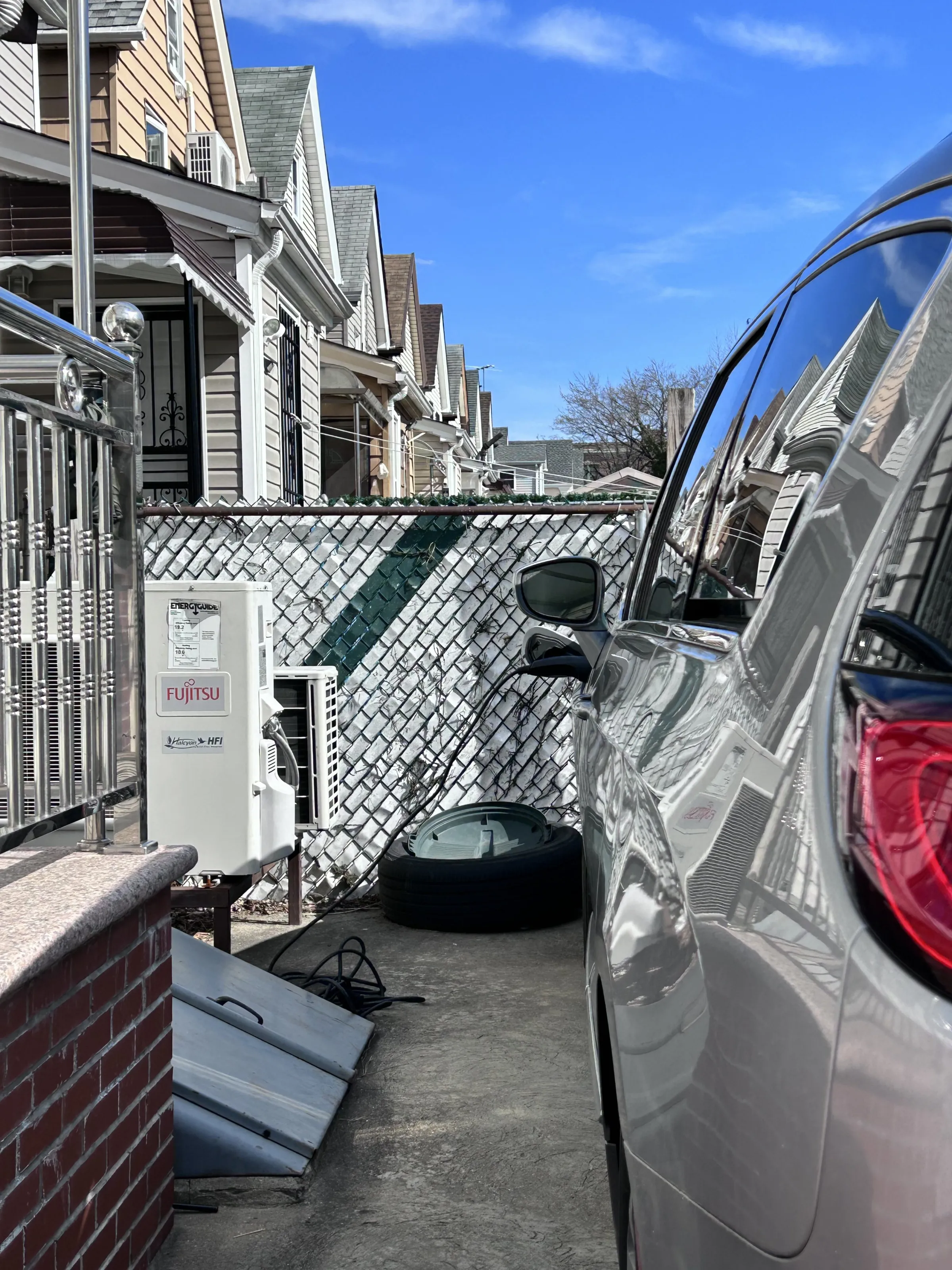 Electric car parked in driveway plugged in and charging with Fujitsu charging station