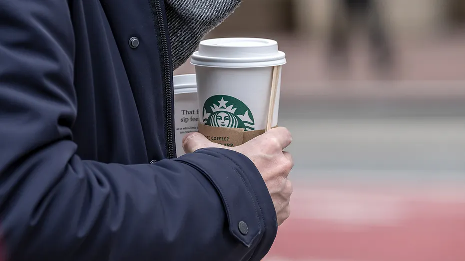 Person holding starbucks coffee cup