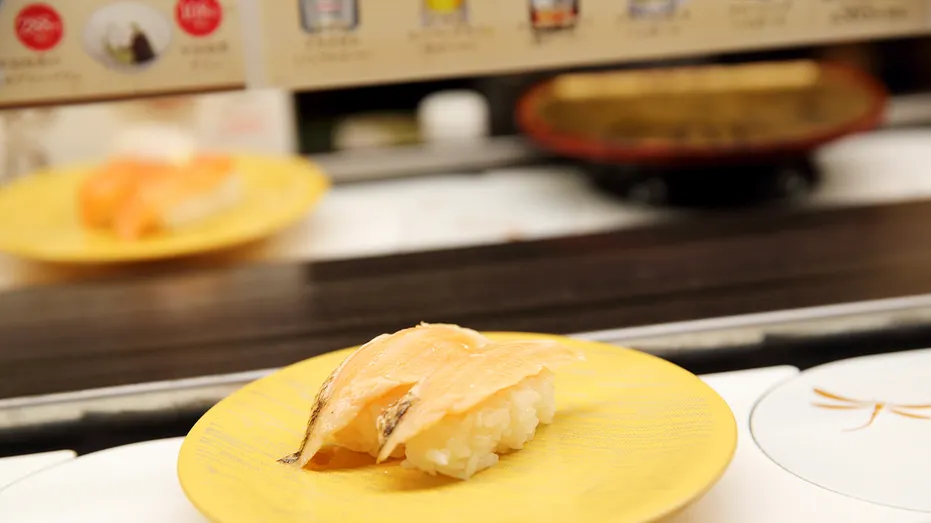two pieces of nigiri moving along a conveyor belt