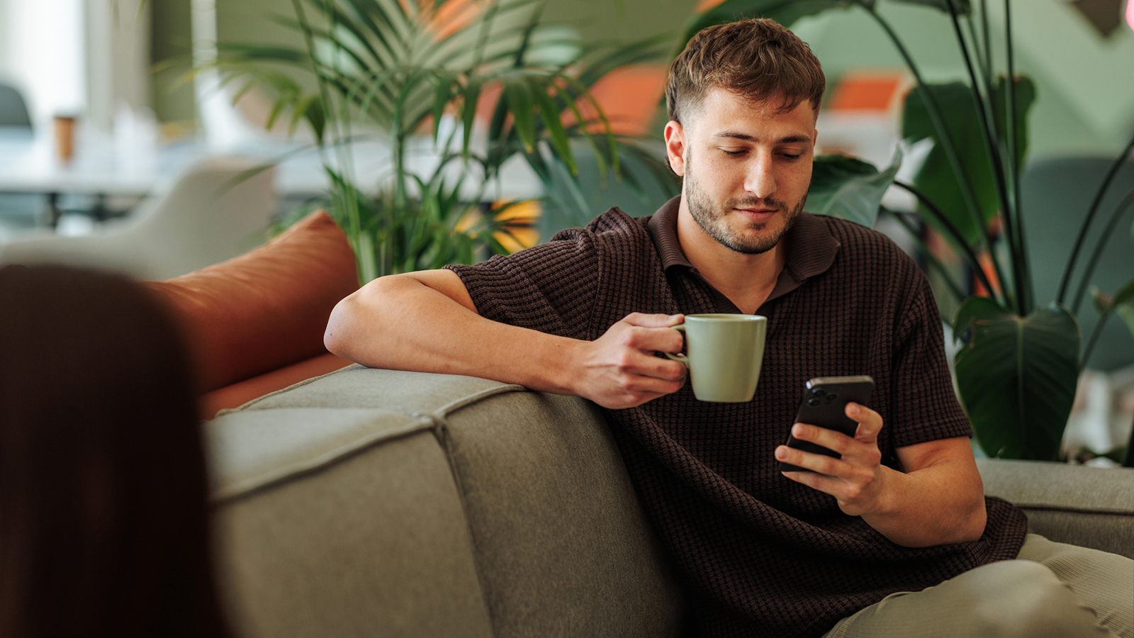 Man looking at a smartphone on the sofa