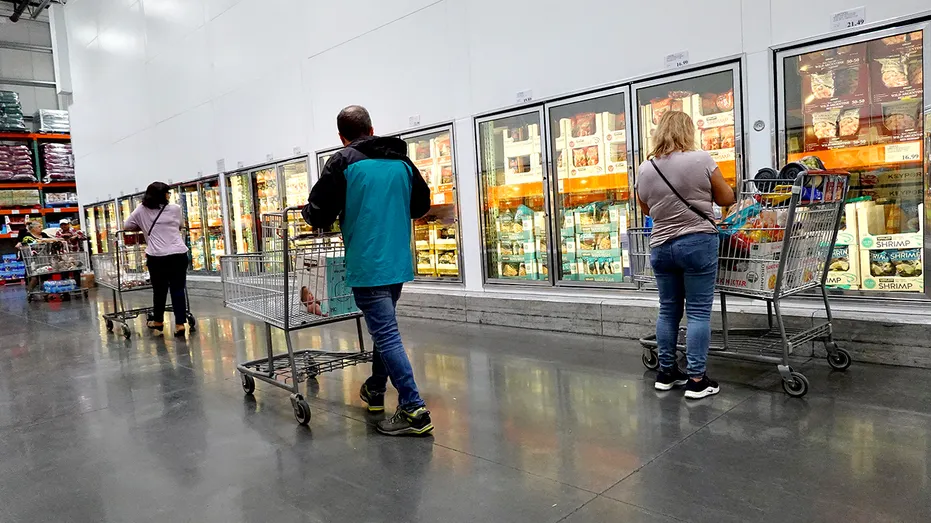 Customers shop at a Costco frozen food aisle