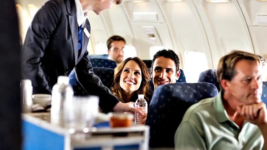 Flight attendant serving customers on an airplane