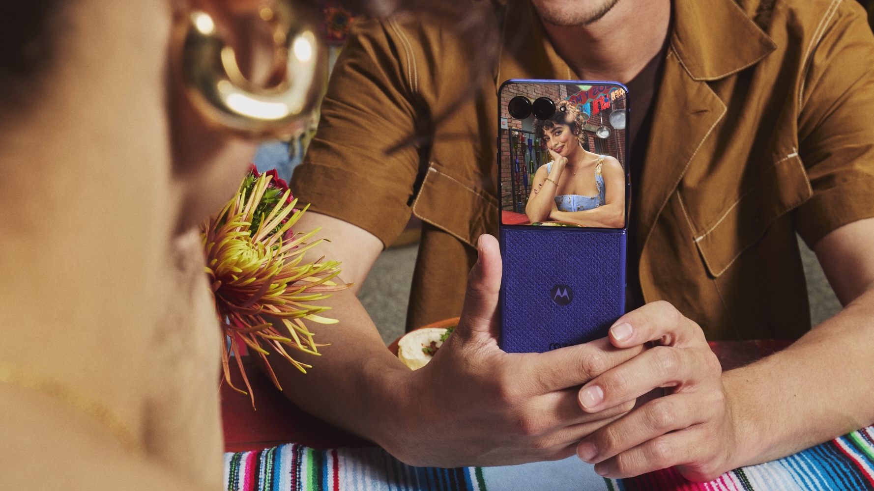 Someone holding the Motorola Razr Ultra 2026 with a woman in the cover screen preview