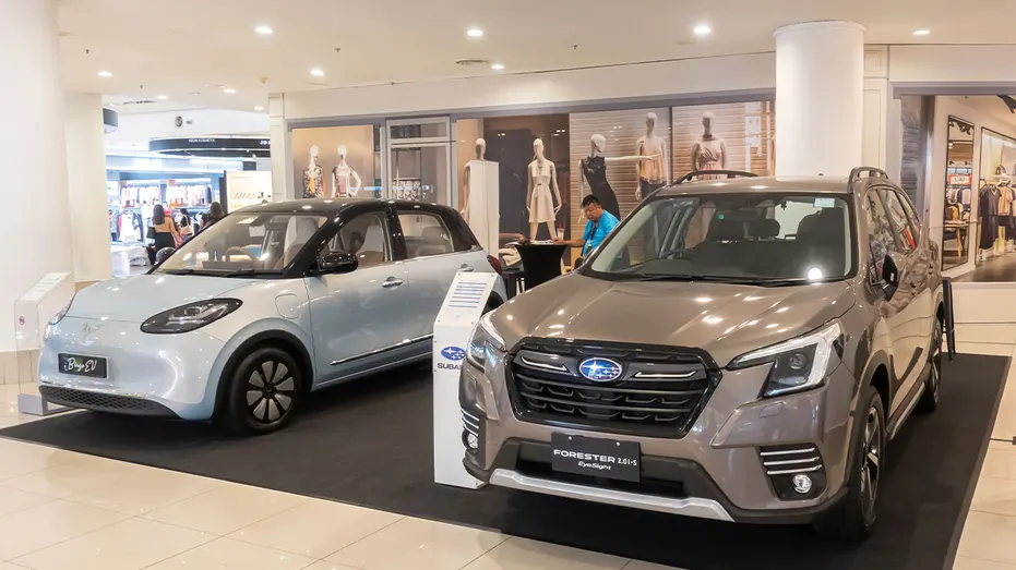 Two cars next to each other at an event: a Subaru Forester and a Wuling Bingo EV
