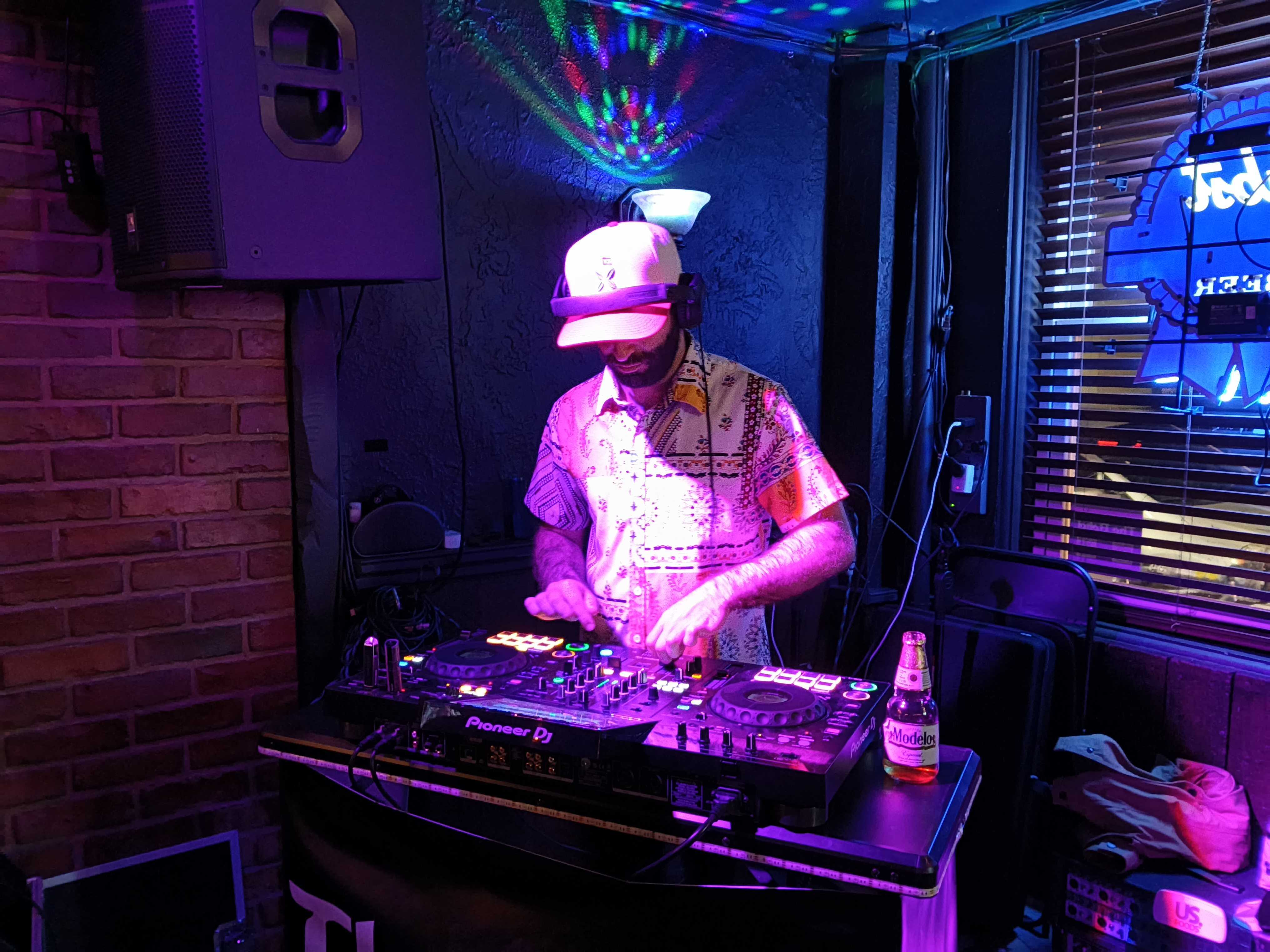 A man in a dimly lit room on a DJ turntable