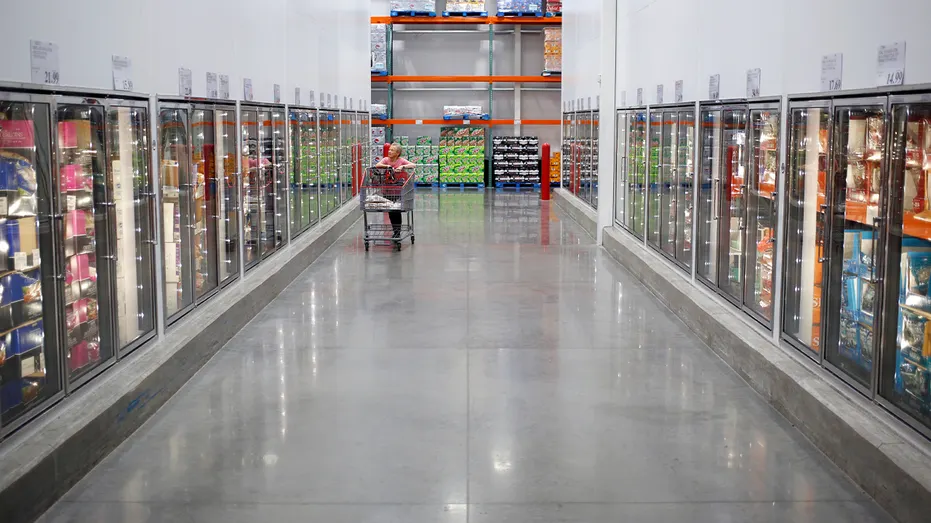 shopper walking through costco fridge aisle