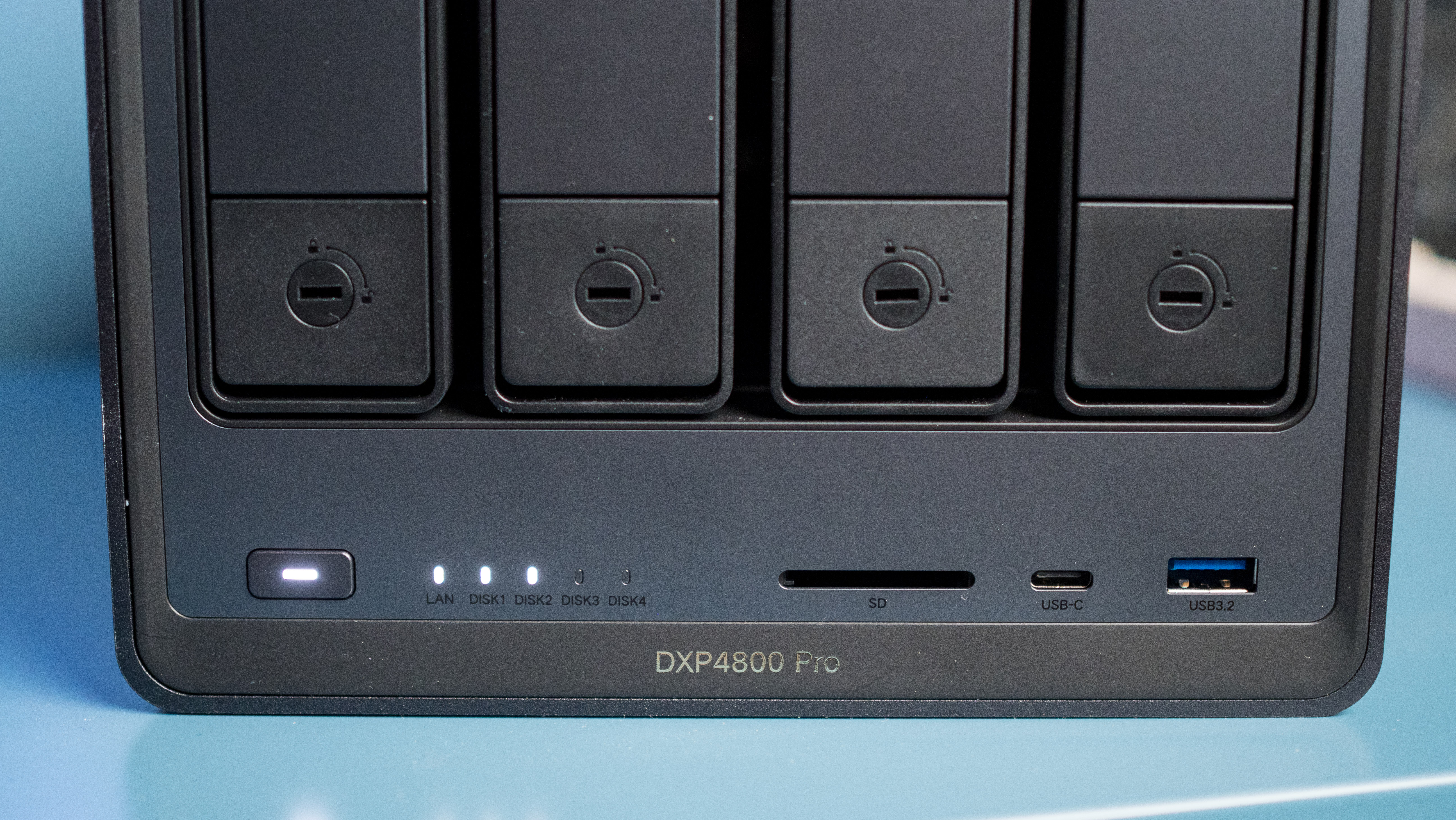 UGREEN DXP4800 Pro 4-bay NAS on a side table showing the drive bays and LED status lights